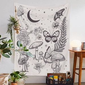 Detail of bohemian black and white tapestry featuring moon, mushroom and floral patterns