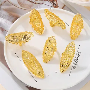 Detailed size comparison of golden hollow bridal rings on a ceramic plate
