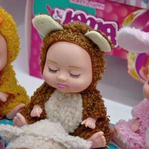 Close-up of 5-inch sleeping baby dolls in plush animal outfits on soft blanket