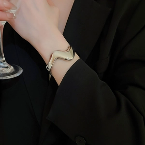 Polished silver irregular wave open bangle cuff with minimalist high-shine metallic finish