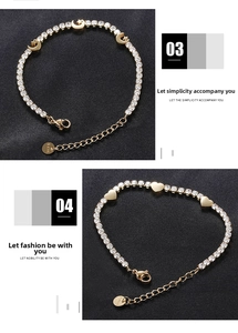 Detail of gold stainless steel star and moon bracelet with heart charm and zircon inlay