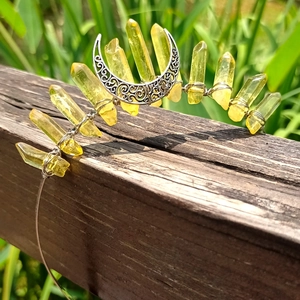 Detail of yellow crystal crown headband with silver moon on rustic wooden fence