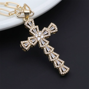 Macro shot of gold cross pendant featuring hollow design and micro-set white gemstones