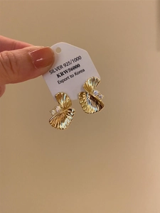 Macro view of 925 silver gold fan earrings with three cubic zirconia stones