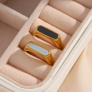 Macro detail of gold plated steel rings with black and white inlays in velvet box