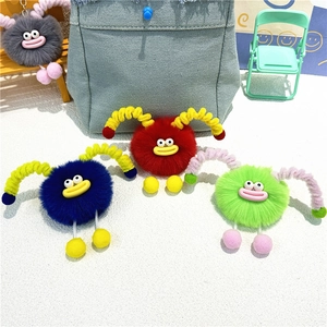 Detail view of colorful plush monster keychains with retractable limbs on a white background