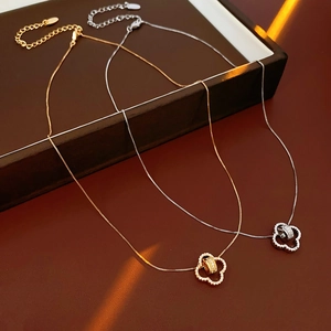 Detailed macro shot of 18K gold and silver plated necklaces with zircon flower pendants