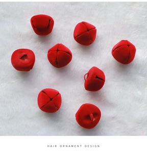 Close-up of 2.5cm red flocked Christmas bells on white plush background for DIY decor