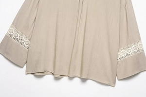 Detailed close-up of white crochet lace cuffs on a khaki linen blend shirt