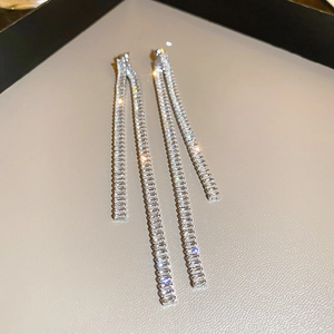 Macro view of long silver tassel earrings with sparkling rectangular zircon stones