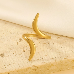 Detail of a matte gold liquid-shaped geometric open ring on a natural stone base