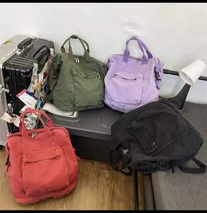 Detail view of canvas backpack in green, purple, red, and black with multiple pockets