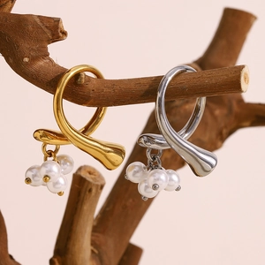 Irregular 18K gold and silver plated open rings with pearl tassels on a wood branch