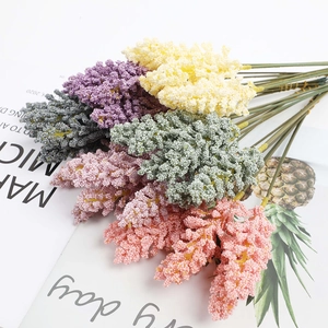 Flat lay of colorful artificial berry stems in purple, yellow, and pink on a magazine
