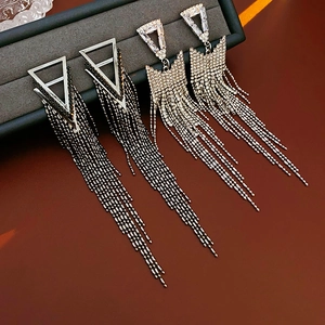Detailed view of geometric triangle tassel earrings with silver and black crystal inlay