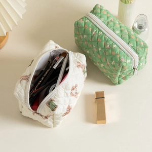 Detail of quilted cotton storage bags with floral and bear patterns for cosmetics