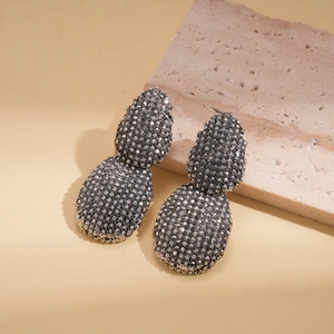 Vue détaillée de boucles d'oreilles gouttes en strass sur des supports en pierre