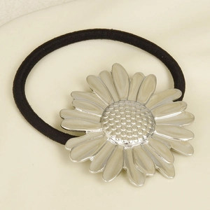 Detailed close-up of a 304 stainless steel daisy charm on a black elastic hair tie