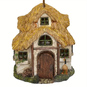 Detailed close-up of a miniature resin thatch cottage with a wood door and white walls
