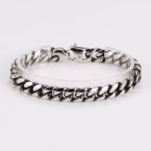 Macro detail of silver stainless steel Cuban link bracelet with vintage black finish and clasp