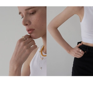 Detail showing a handmade daisy elastic ring with freshwater pearls and layered necklace