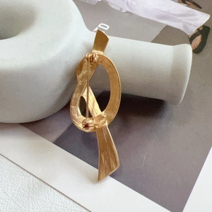 Detailed view of vintage gold knot brooch showing textured metal and secure pin clasp