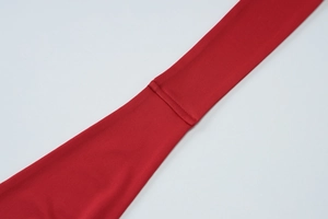 Détail du tissu en maille rouge haute élasticité montrant la couture et texture