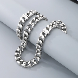 Detail of 13mm silver Cuban link chain wrapped on a cylindrical display stand