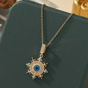 Macro shot of gold Evil Eye necklace pendant with blue enamel and sparkling rhinestones