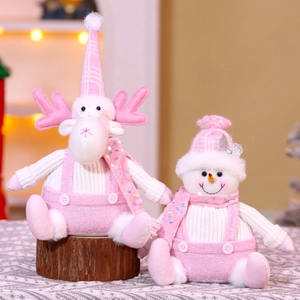 Close-up of pink sequined Christmas reindeer and snowman plush dolls on wooden base