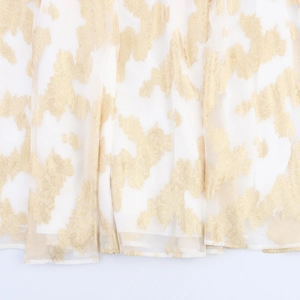 Robe blanche sans manches élégante avec motif doré luxueux et tissu fluide
