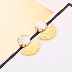 Detail of gold geometric earrings with round pearl shell inlay and radiant sunburst base