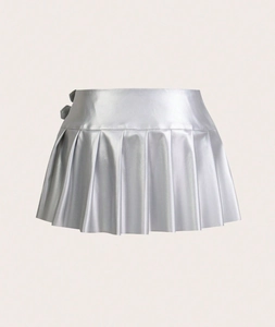 Detail of silver metallic pleated mini skirt featuring adjustable side buckle and glossy finish