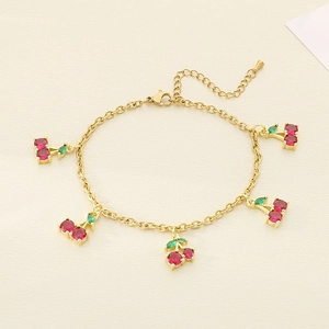 Detailed macro view of cherry charm pendants with red and green zircons on gold chain