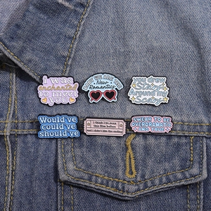 Set of 6 colorful enamel pins with inspirational lyrics on a blue denim jacket