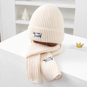 Detail of cream knit hat and scarf set featuring cute dachshund dog embroidery detail