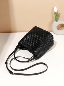 Handwoven black leather bucket bag with checkerboard pattern and adjustable strap