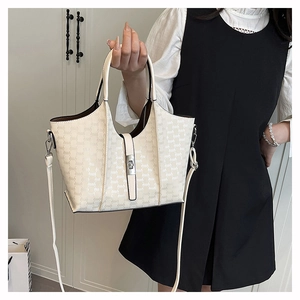 Detail of white tote bag with letter monogram print and adjustable shoulder straps