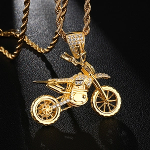 Close-up of a gold motocross pendant with sparkling crystals on a twist rope chain