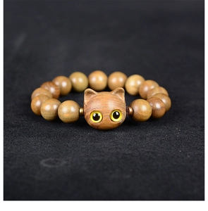 Gros plan du grain de bois naturel et de la perle chat sur ce bracelet en bois de santal