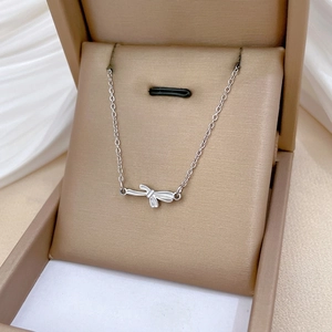 Minimalist bow-knot stainless steel necklace displayed in a luxury velvet jewelry gift box