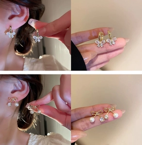 Detail of gold-plated butterfly earrings with crystals and pearls shown on ear and hand