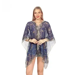 Detail of navy blue bohemian kaftan with gold chain patterns and wide sleeves