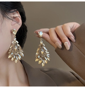 Detailed view of champagne gold chandelier earrings with marquise and teardrop crystals