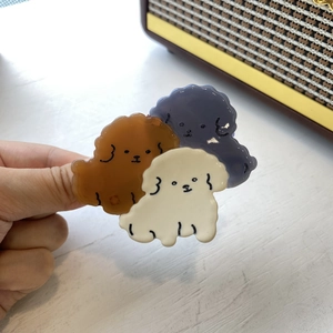 Detailed view of three cute acetate puppy hair claws in brown, white and grey colors