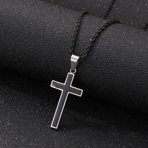 Close-up of black stainless steel cross pendant with silver edges and braided chain