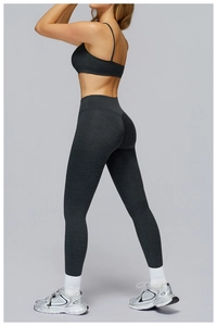 Detail of grey racerback sports bra and high-waist yoga pants on studio model