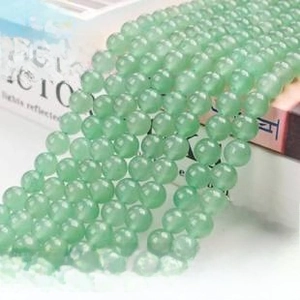 Macro view of polished round green aventurine beads neatly arranged for jewelry making