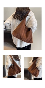 Close-up of a brown suede hobo bag with a wide shoulder strap in a casual style