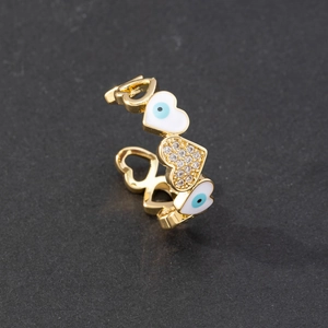 Detailed macro shot of gold heart ring with enamel evil eye and sparkling zircons